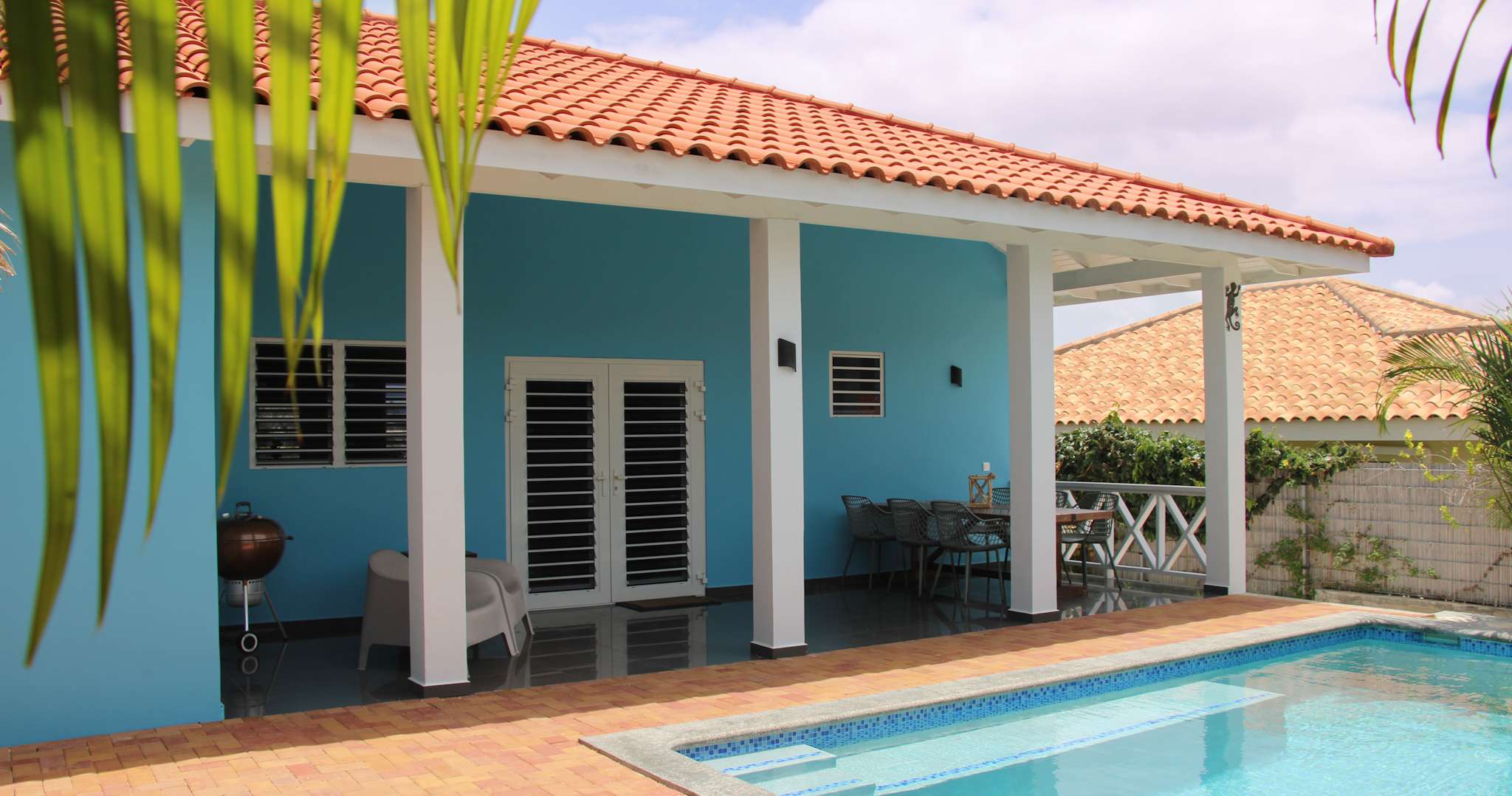Wide view of the villa with covered porch and pool