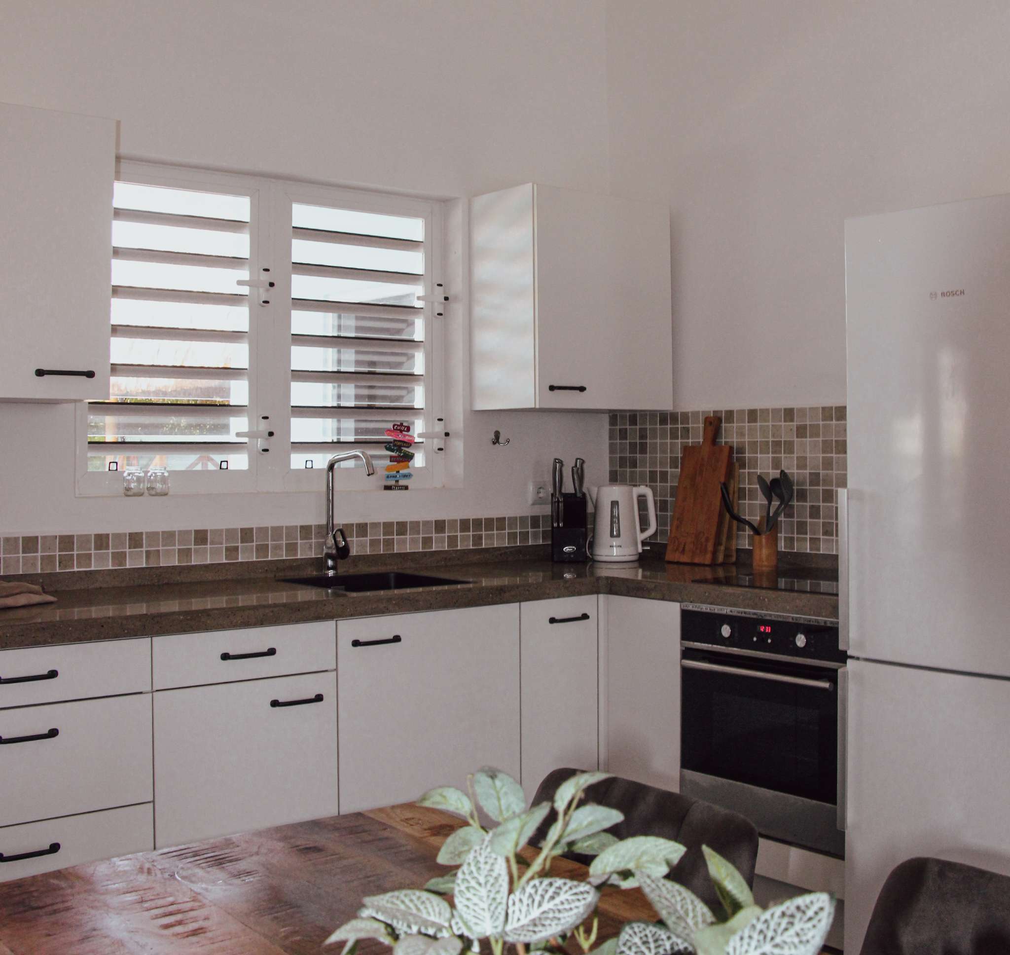 Kitchen with Bosch oven and fridge-freezer, seen from the dining table