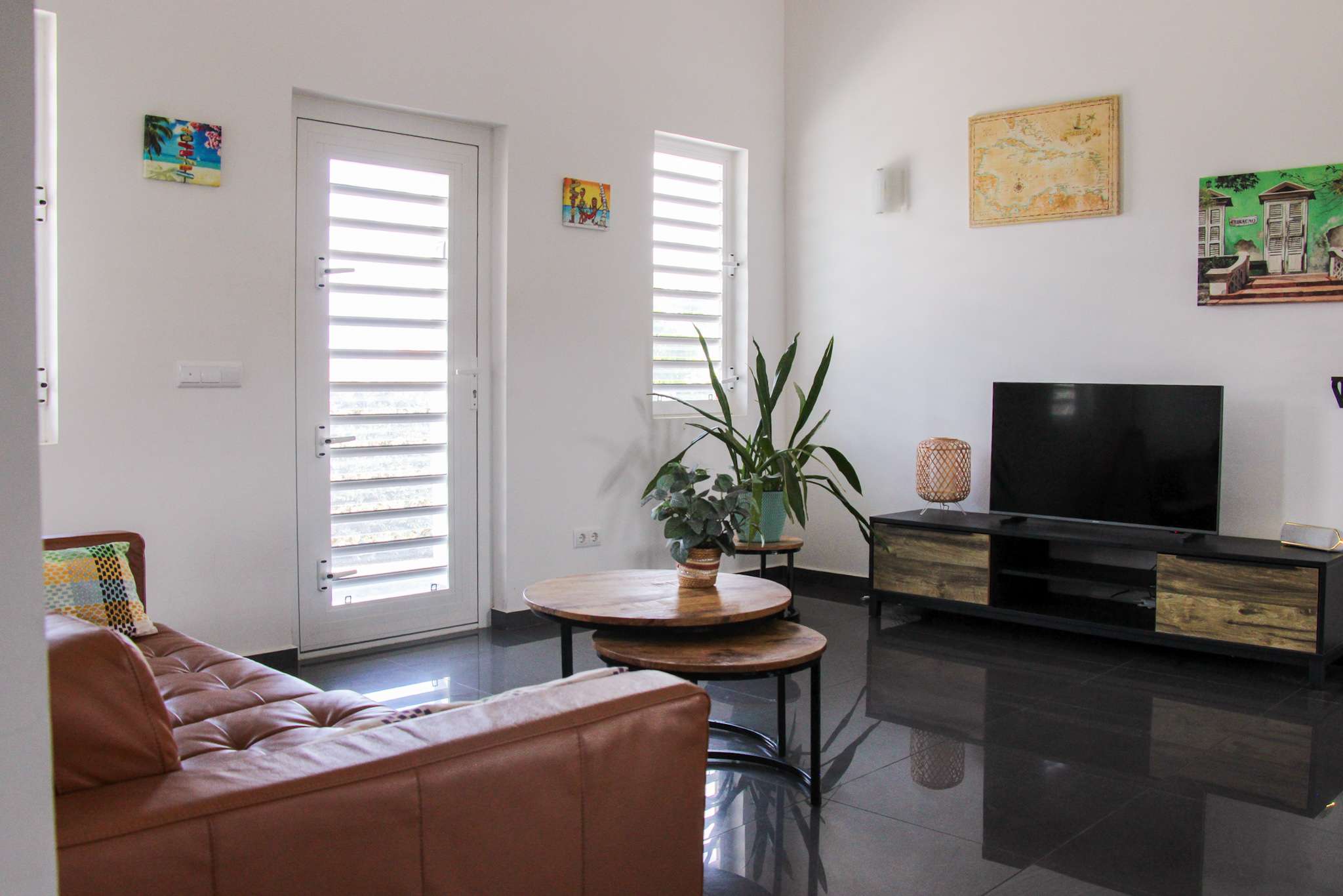 Living room with leather sofa, round coffee tables and smart TV