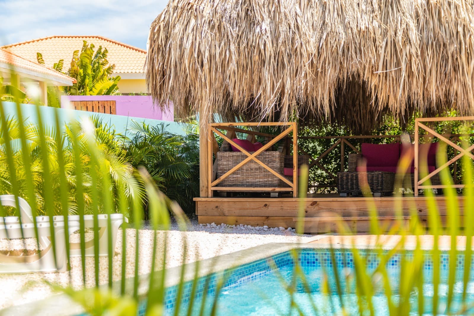 Palapa met loungeset gezien vanaf het zwembad